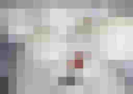 Modernes Büro mit großem Schreibtisch, rotem Designstuhl und innovativer Beleuchtungskugeln