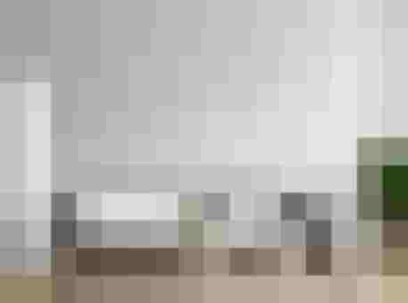 Modernes Wohnzimmer mit grauem Sofa und weißer Stele